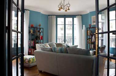 Peinture salon contemporain bleu turquoise et blanc Une peinture salon bleu turquoise dans une déco contemporaine. Une couleur design et élégante en association avec du blanc ici sur les rideaux et boiseries