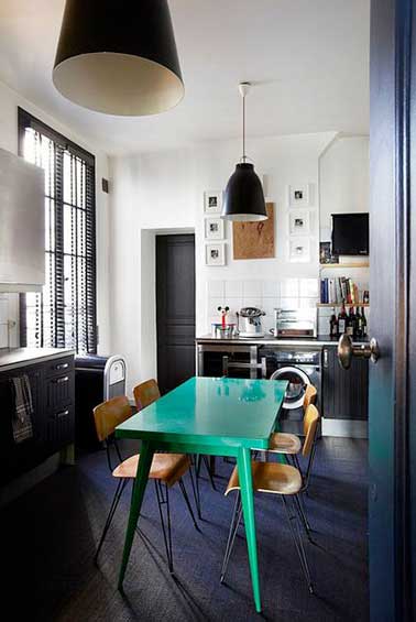 Une table de cuisine repeinte en vert c'est la touche funky de la déco de cuisine. Associée à une peinture noir satin pour repeindre les meubles de cuisine, le parquet et les portes de cuisine