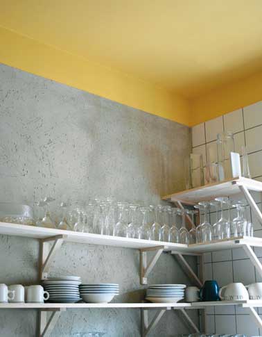 Un couleur jaune pétillante pour peindre le plafond donne des couleurs à cette cuisine grise. Une peinture choisie aussi pour apporter de la lumière à la pièce