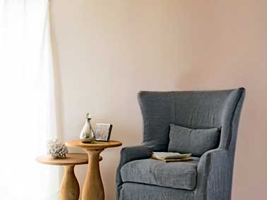Une peinture Tollens rose poudre habille les murs de ce salon cosy. Une nuance douce qui valorise le petit fauteuil en velours gris et les tables basses en bois 