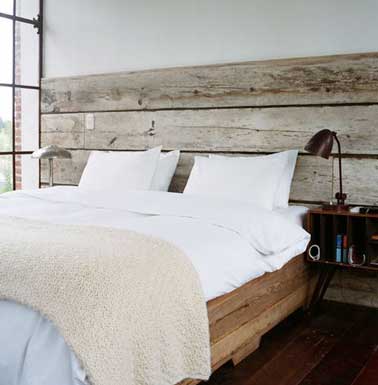Fabriquée en bois flotté cette tête de lit recup fait la déco nature de la chambre. En harmonie avec le bois du lit et le style rétro des lampes et du chevet