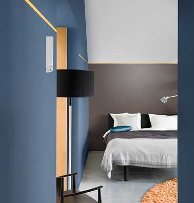 Des traits de peinture jaune sont tracés pour structurer les murs de cette chambre moderne. Effet lumineux et doux avec la peinture couleur Jaune Ambré. Dulux