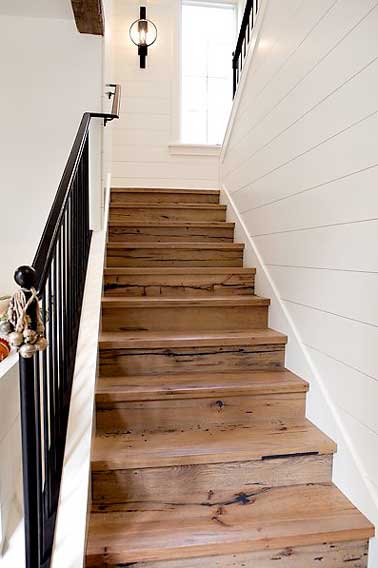 Un escalier se transforme avec du bois de palette collé sur les marches et contre marches. Une idée déco économique et facile à refaire pour une rénovation 