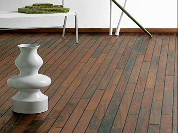 Déco moderne avec un parquet de salle de bain en mutenye. Ses nuances marron foncé sont parfaites avec une baignoire îlot et des meubles design