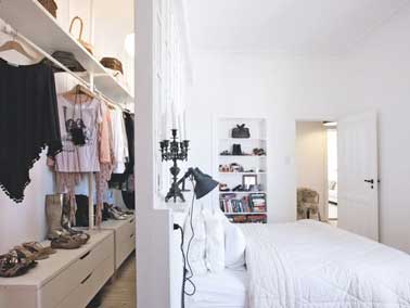 Futé, le dressing aménagé derrière le mur de tête de lit de la chambre parentale. Un espace étroit bien exploité avec penderie, étagères et grands tiroirs en bois blanc