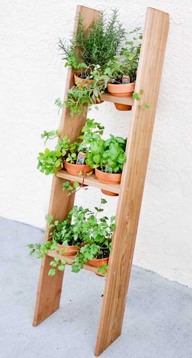 Une échelle en bois relooké pour recevoir des pots de plantes et faire un jardin potager suspendu inattendu. A poser contre le mur d’un balcon ou d’une terrasse. 