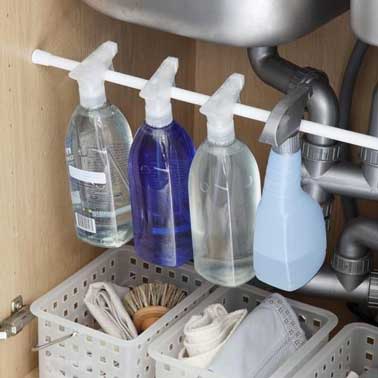 Pour ranger les produits d'entretien dans une cuisine, le meuble sous évier s'organise avec des paniers en plastique et une barre pour suspendre spray et vaporisateurs, de sorte à gagner de la place pour ranger tous les accessoires. 