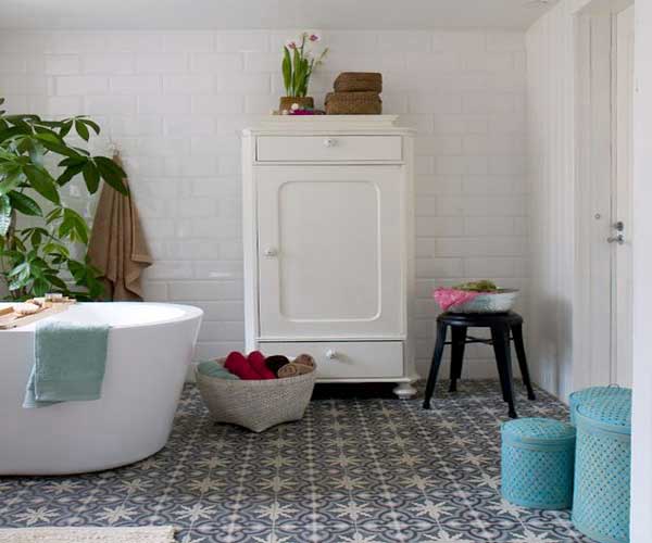 Carrelage métro blancs et sol en carreaux de ciment motifs floraux noirs et blancs font la déco vintage de la salle de bain
