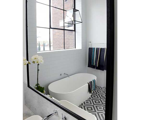 Carreaux de ciment géomtriques et plan vasque en marbre blanc assurent la déco design de cette grande salle de bain.