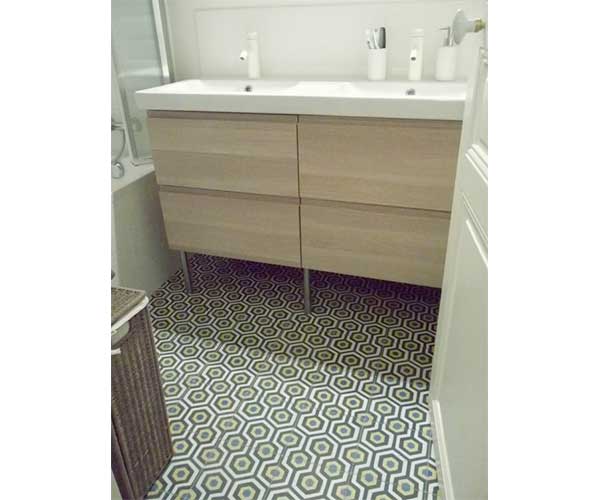 Carreaux de ciment géométriques verts et blancs dans petite salle de bain contemporaine. Modernisé par le meuble sous lavabo double vasque en bois clair et les murs blancs de la pièce.