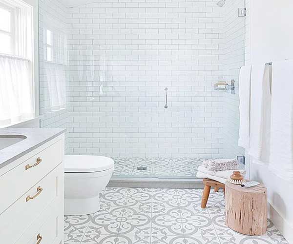 Salle de bain moderne avec un sol en carreaux de ciment motifs gris et blancs. Marié avec le carrelage métro blanc des murs de la douche italienne, il donne des couleurs à la salle de bain blanche.
