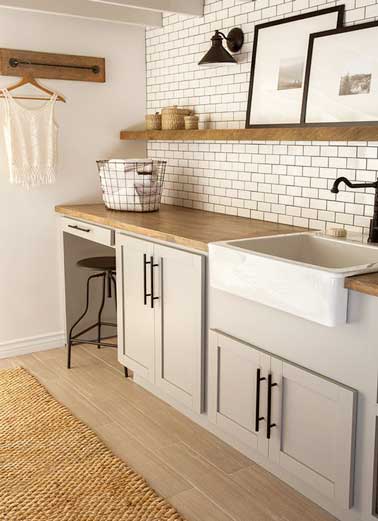 Cuisine vintage réalisée avec carrelage métro blanc. Sublimé par détails bois du plan de travail et de l’étagère il s’harmonise aux peintures claires des meubles bas et des murs.