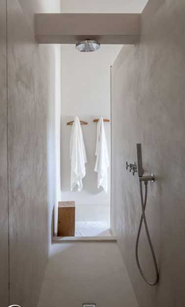 Une douche à l’italienne construite dans un espace étroit en béton ciré. Simple et minimaliste, elle possède une douche pluie encastrée dans un coffrage sur mesure.