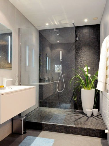 Douche italienne en carrelage noir dans salle de bain design Jouez les contrastes de couleurs pour créer une salle de bain design en adoptant des carreaux de céramique noir dans la douche italienne et du carrelage blanc sur les murs et les meubles