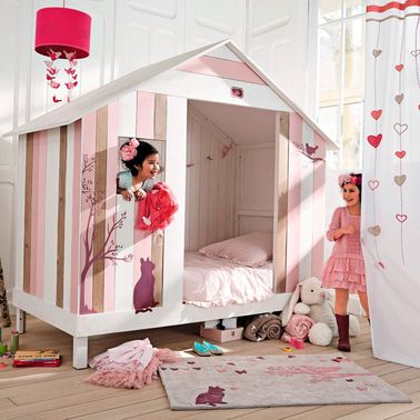 Un lit cabane rose pour fille de chez Maisons du Monde Un lit cabane prend peu de place mais donne du caractère à une chambre de petite fille. Le tapis assorti Maisons du Monde renforce le côté cosy de ce petit nid douillet.