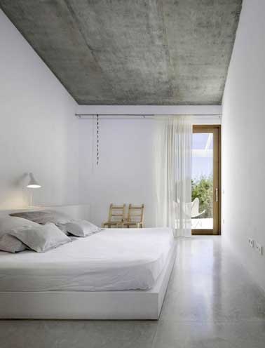 Déco monacale dans une grande chambre. A refaire en choisissant des matériaux bruts et nobles. Ici des dalles de béton posées sur le plafond et du marbre gris en revêtement de sol. 