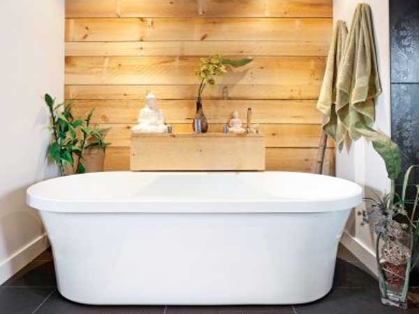 Ambiance zen et exotique autour de la petite baignoire ilot avec un mur réalisé en planches de pin naturel