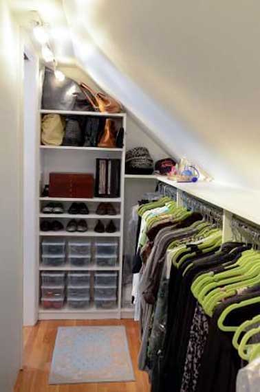Dans un espace étroit un dressing sous pente est crée avec une barre de penderie fixée tout le long du mur. Placards ouverts et étagères exploitent la hauteur sous plafond