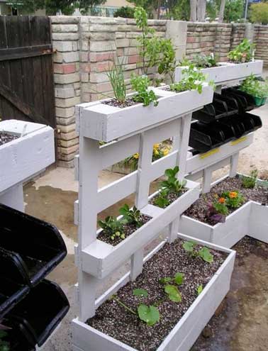 Jardin potager suspendu fait avec des palettes bois peintes en gris. Assemblées entre-elles pour former trois caissons de tailles différentes elles font la déco d’extérieur.