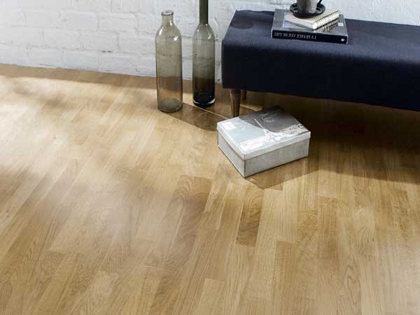 Avec son aspect verni et sa couleur clair, ce parquet flottant en chêne modernise le salon. Parquet chêne standard, 3 frises clair. Adapté au chauffage par le sol. Saint Maclou.