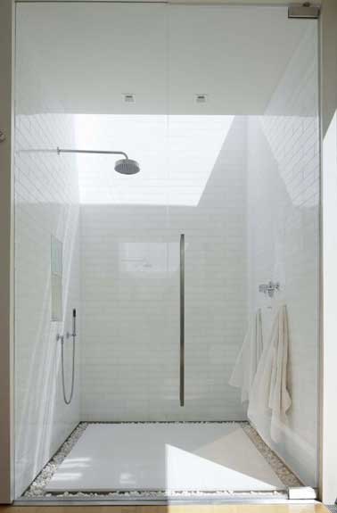 zen la douche à l’italienne avec son grand receveur antidérapant posé sur un parterre de galet. Elle est isolée de la salle de bain avec deux portes de douche.