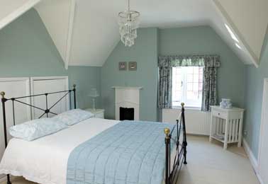 Couleur de peinture chambre bleu pastel et blanc pour déco rétro. Les murs bleu pastel s’harmonisent à la couette et le plafond et les boiseries blanches équilibrent la pièce. Farrow&Ball