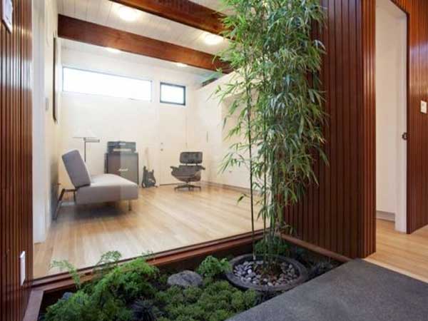 Terrasse en bois pour le jardin zen avec ce petit coin de verdure bordé de palissades en bois. Bambou en pot et tapis de mousses apaisent la composition.