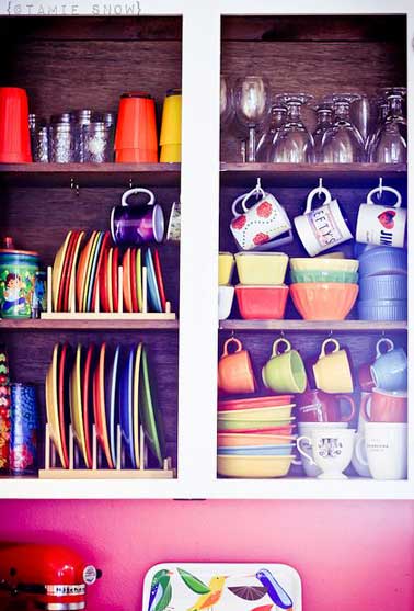 Enlevez les portes d’un meuble de cuisine recup et exposez fièrement votre vaisselle sur le plan de travail. Accessible il accueille tasses à café, verres et assiettes aux couleurs multicolores
