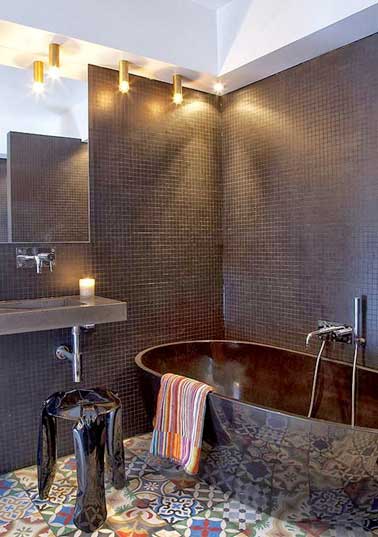 Salle de bain design avec carrelage sol en carreaux de ciment Carreaux de ciment patchwork posés sur le sol d’une salle de bain design. Sublimés par les murs en carrelage mosaïques noirs et la baignoire îlot acrylique noire ils dynamisent la déco