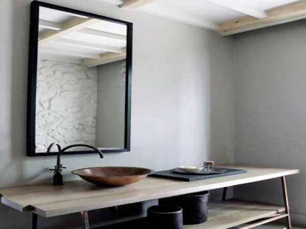 Plan vasque en bois naturel, peinture grise et robinetterie noire colorent cette salle de bain zen
