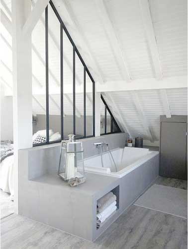 Une verrière intérieure est posée sur une cloison tête de lit de la suite parentale. Aménagée sous pente, elle permet de séparer la salle de bain de la chambre. 