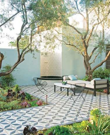 Exemple d’aménagement de terrasse avec un revêtement en carreaux de ciment bleus et blancs. Sobres et authentiques, ils s'harmonisent avec la couleur bleu pastel de la clôture du jardin