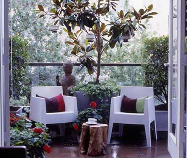 Donnez une allure de jardin zen au balcon en adoptant une statue bouddha et deux chaises de jardin aux lignes incurvées. Magnolia et table de jardin rodin de bois en symétrie quasi parfaite