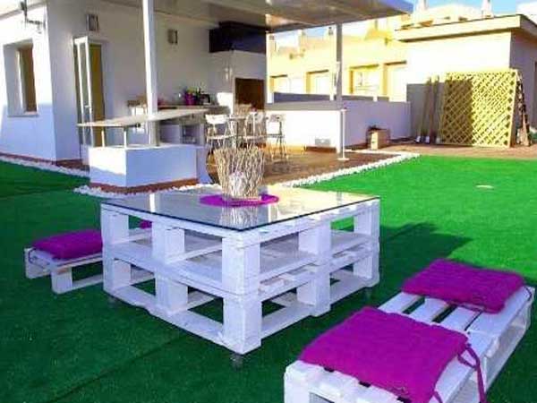 Un salon de jardin fait avec deux palettes en bois recouverte de peinture blanche. A compléter avec des bancs coordonnées