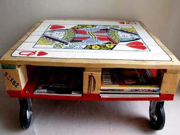 Une table basse palette devient table de jeux avec un poster collé sur le plateau et un fond coloré avec une peinture rouge