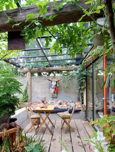 Toit verrière et vigne installent l’ambiance cabanon de cette terrasse. Aménagé avec du mobillier de jardin et des matériaux de récupération, son charme est unique