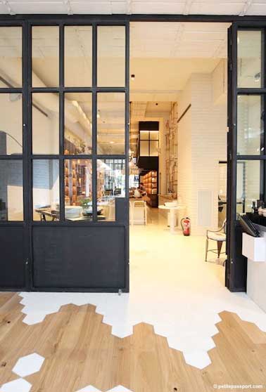 Cette verrière d’intérieure pivotante s’harmonise avec le parquet et le carrelage blanc. Ouverte en partie ou complètement, elle module ce grand espace à la demande. 