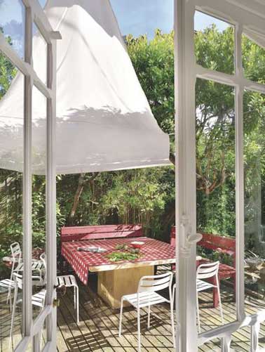 Nichée au milieu de la végétation cette terrasse accueille toute la famille autour de sa grande table en bois. Voile d’ombrage et sol en bois souligne sa convivialité