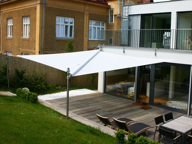 Un voile d’ombrage télécommandé protège la terrasse du soleil ou de la pluie et fait office de barnum automatique, en plus beau : on adore pour un jardin moderne !