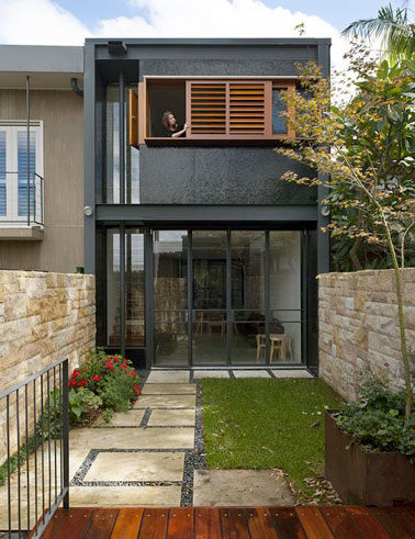 Une extension maison contemporaine est réalisée au dessus d’un garage pour agrandir l’espace. Un grand séjour prend place dans cette extension verrière lumineuse et ouverte sur le jardin.