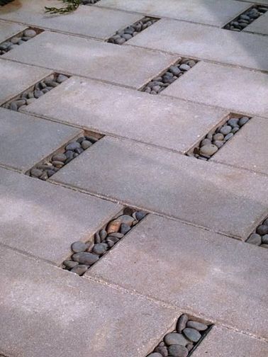 Une allée de jardin en dalles de béton et galets Les dalles de béton sont un moyen facile d'aménager votre allée de jardin, comme ici où elles sont disposées en décalé. Pour combler les trous, on a utilisé de simples galets.