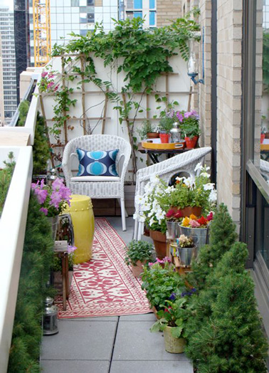 Des chaises en rotin blanc, un joli tapis coloré, des plantes et des fleurs, voilà un aménagement hyper déco sur ce balcon en longueur ! Un espace extérieur idéal pour se relaxer 