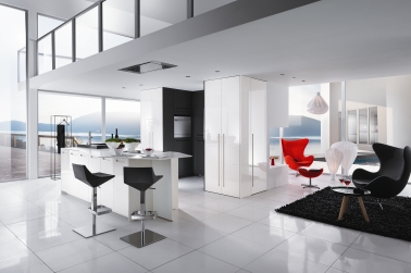 Une cuisine blanche contemporaine intégrée dans le séjour Cette cuisine blanche est la star d’un appartement style loft où elle se fond dans le déco avec légèreté. L’avantage ? De nombreux rangements pour un plan de travail toujours net.