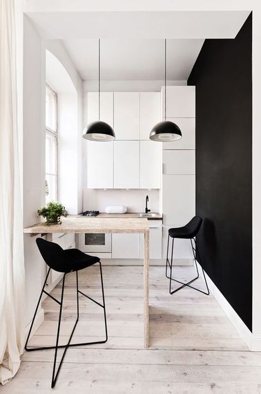 Une cuisine blanche et noire ouverte Un bar est une bonne idée pour séparer une cuisine américaine ouverte d’une pièce en longueur : il servira de plan de travail supplémentaire pour cuisiner, et de coin repas.