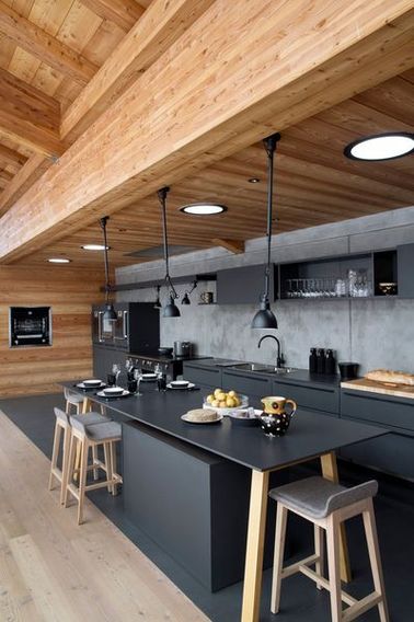 Une cuisine ouverte grise avec des poutres apparentes