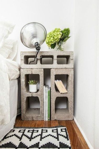 La déco peu meublée de cette chambre noire et blanche ne donne pas une impression de vide grâce à la tête de lit capitonnée et au mur tapissé de papier journal.