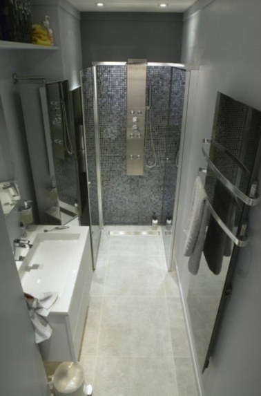 Une déco esthétique pour cette salle de bain en longueur grise. Léger et non poreux, le carrelage sol imitation béton vous facilite la vie tant pour la pose que pour l’entretien.