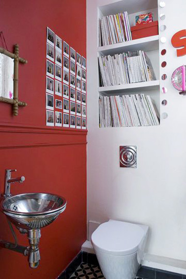 Une superbe idée pour aménager des toilettes uniques qui ne manquent pas d’originalité ! Une déco rouge et blanche pour des toilettes où une petite bibliothèque s’est judicieusement installée au dessus du WC