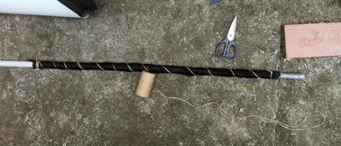 Pour la troisième étape de ce DIY déco qui embellira votre jardin, enroulez le petit tuyau de tissu géotextile et faites tenir le tout solidement grâce à de la ficelle. 