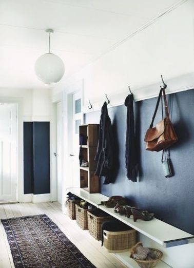 Une déco de hall d’entrée hyper bien aménagée avec des rangements pour les chaussures et manteaux tous simples fait de patères, paniers et plateau stratifié.
